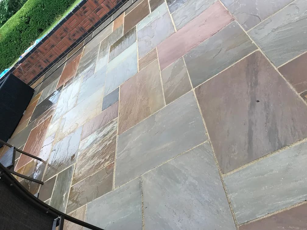 Close-up of natural stone patio slabs with mortar joints, laid in a Leicester garden.