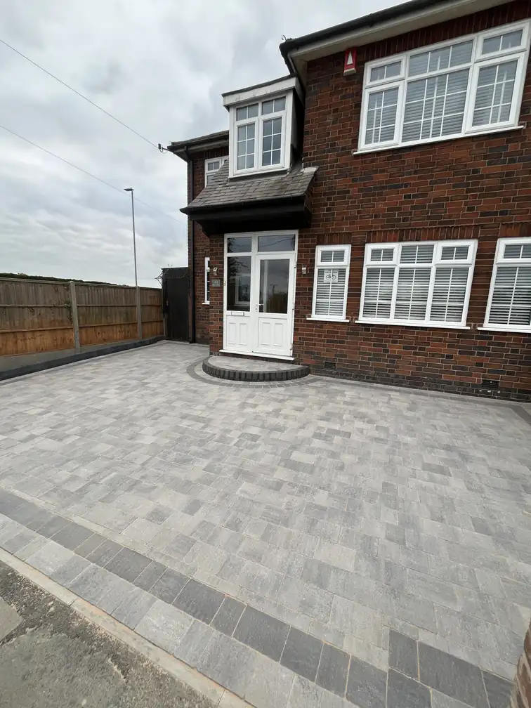 Full block paving installation wrapping a detached brick home, maximising parking and kerb appeal.