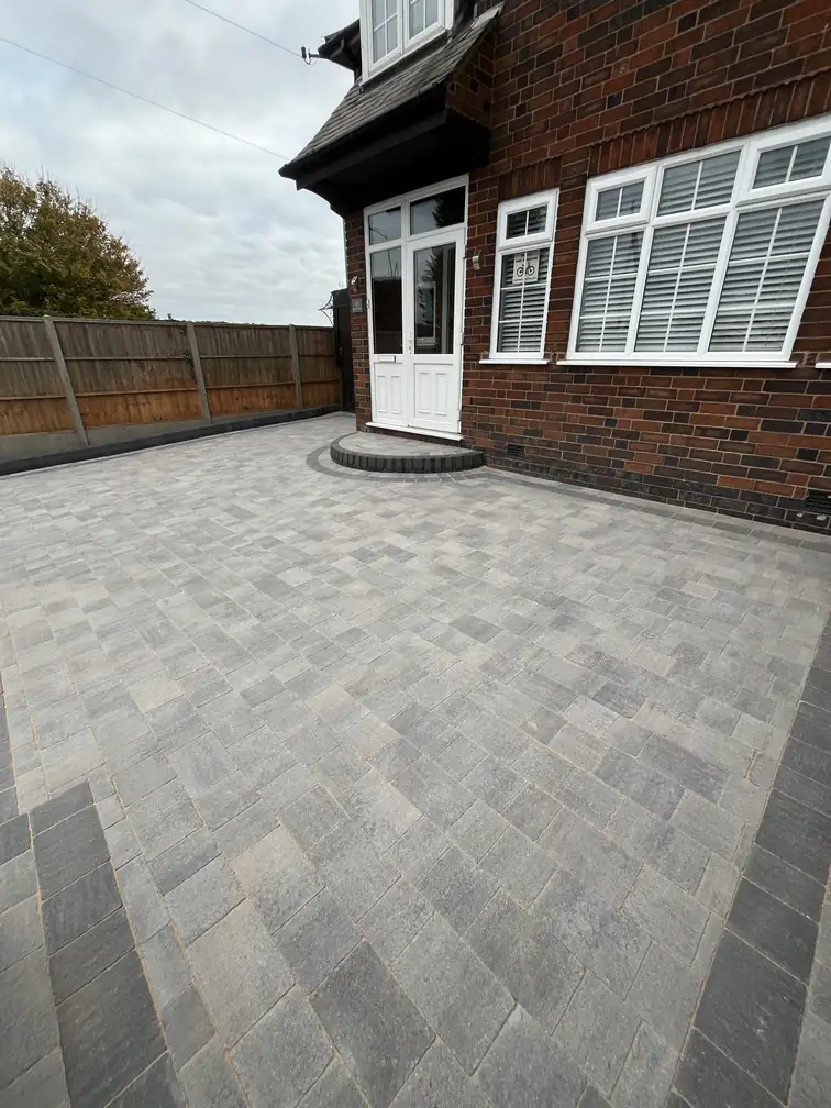 Grey block paving transforming a courtyard garden into clean usable space with minimal upkeep.