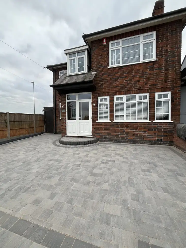 Large block paved driveway continuing into the rear garden of a brick semi, seamless practical surfacing throughout.