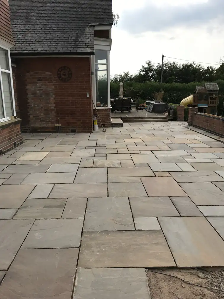 Large Indian sandstone patio at a period property, laid in a random pattern for a timeless entertaining space.