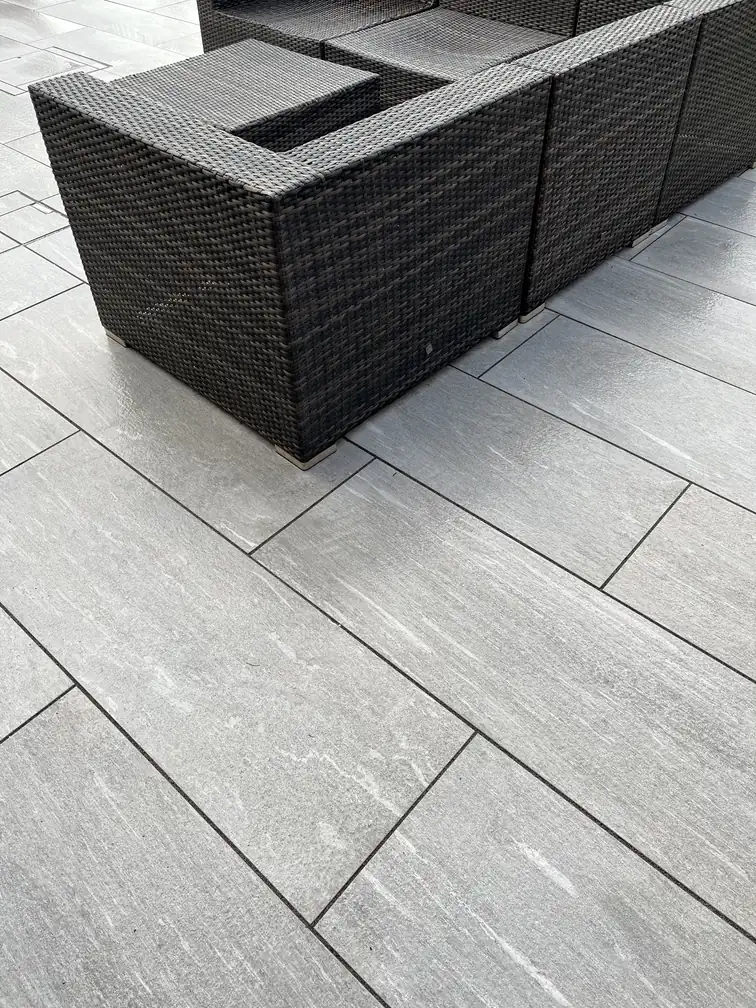 Plank-format porcelain paving with a rattan cube dining set, wood-look durability with none of the upkeep.