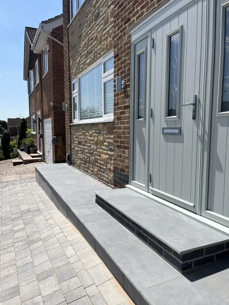 Porcelain entrance steps with contrasting riser detail at a grey composite front door, a smart durable welcome.