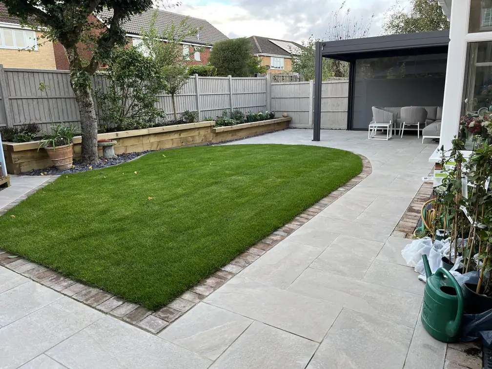 Garden makeover with porcelain patio, new lawn and timber sleeper raised beds leading to a modern seating pergola.